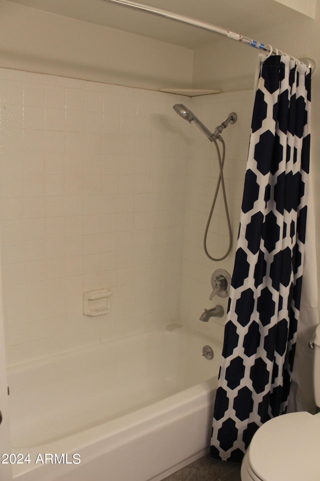 bathroom featuring shower / bathtub combination with curtain and toilet