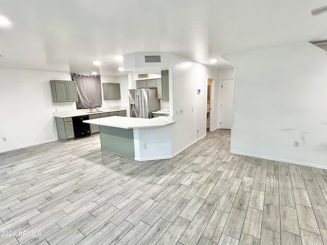 kitchen featuring gray cabinetry, sink, light hardwood / wood-style flooring, stainless steel fridge, and kitchen peninsula