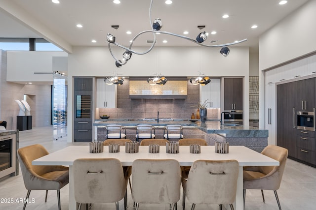 kitchen with a towering ceiling, tasteful backsplash, and modern cabinets