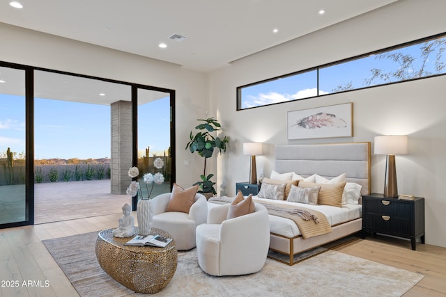 bedroom with access to exterior, multiple windows, visible vents, and wood finished floors