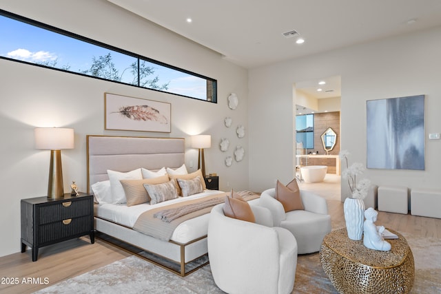 bedroom featuring ensuite bath, visible vents, wood finished floors, and recessed lighting