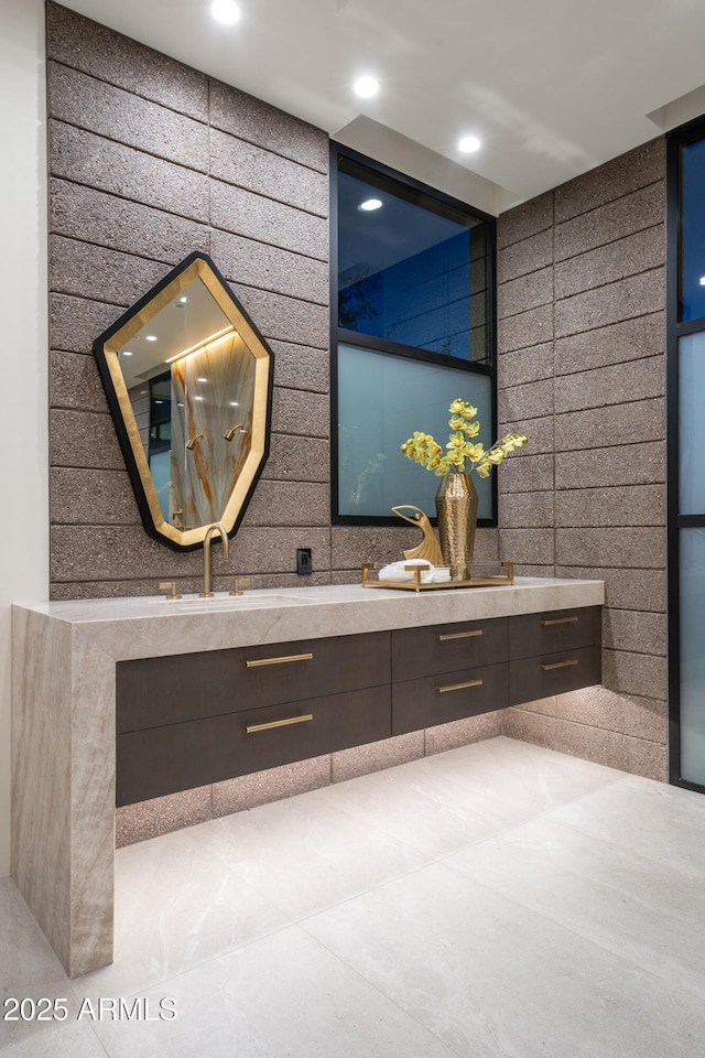 full bathroom with double vanity, a sink, and recessed lighting