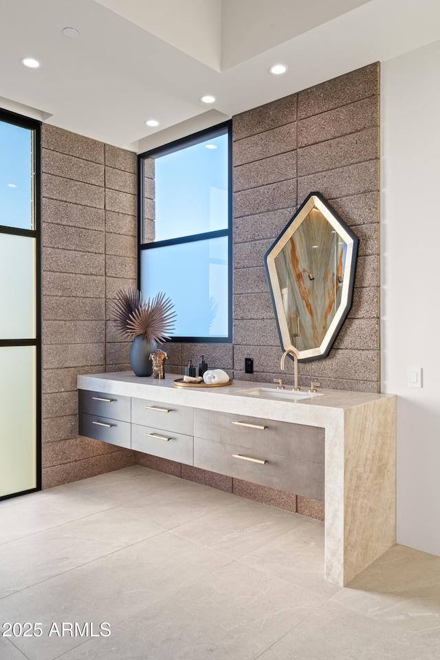 bathroom featuring a wealth of natural light, a sink, recessed lighting, and double vanity