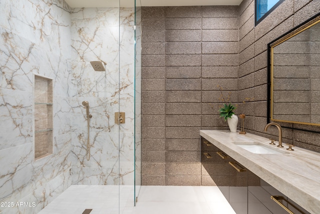 full bathroom featuring a marble finish shower and vanity