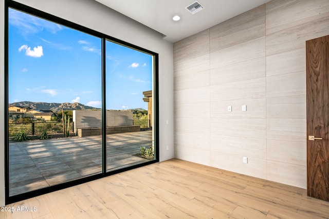 empty room with visible vents and wood finished floors