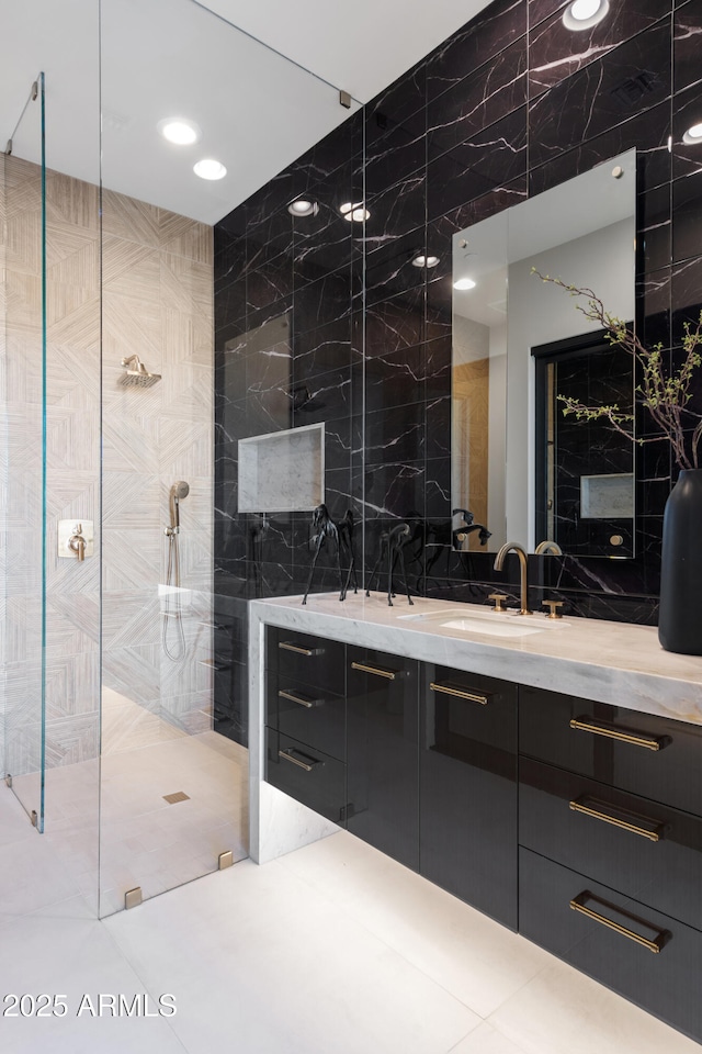 full bath featuring tile walls, vanity, and a walk in shower