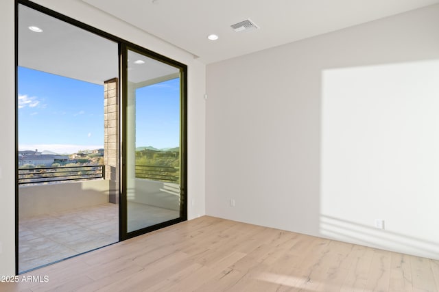 spare room with recessed lighting, visible vents, and wood finished floors