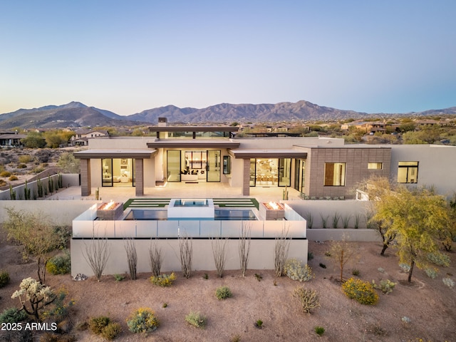 back of property featuring a patio area, a fenced backyard, a mountain view, and a fenced in pool