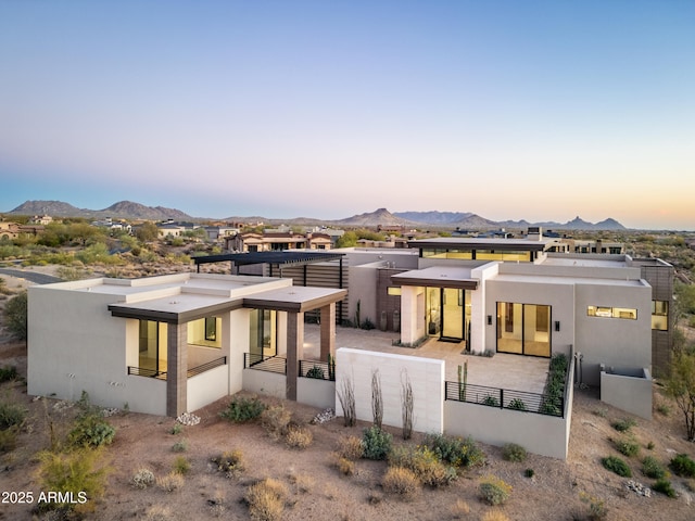 view of front of home featuring fence, a mountain view, and stucco siding