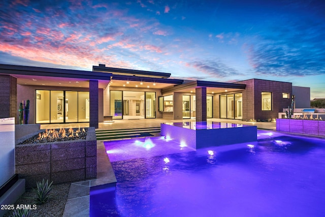 outdoor pool with a patio area and a fire pit