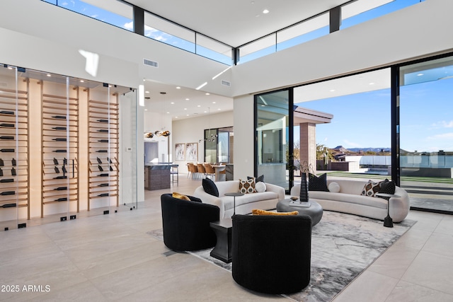 tiled living room featuring a high ceiling and visible vents