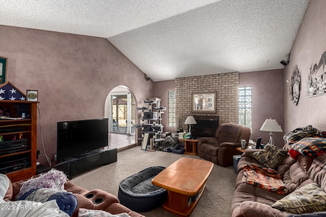 4957 W Onyx Ave, Glendale, AZ 85302 - living area featuring lofted ceiling, carpet flooring, arched walkways, a textured ceiling, and a brick fireplace