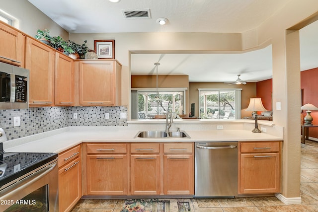 16857 W Villagio Dr, Surprise, AZ 85387 - kitchen with stainless steel appliances, a sink, ceiling fan, light countertops, and backsplash