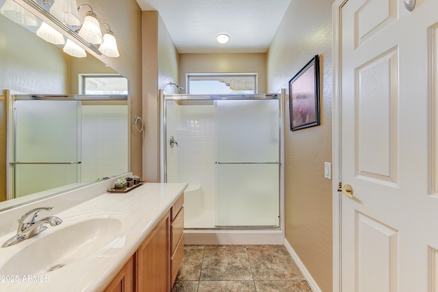 16857 W Villagio Dr, Surprise, AZ 85387 - full bathroom featuring a stall shower, vanity, baseboards, and a textured wall