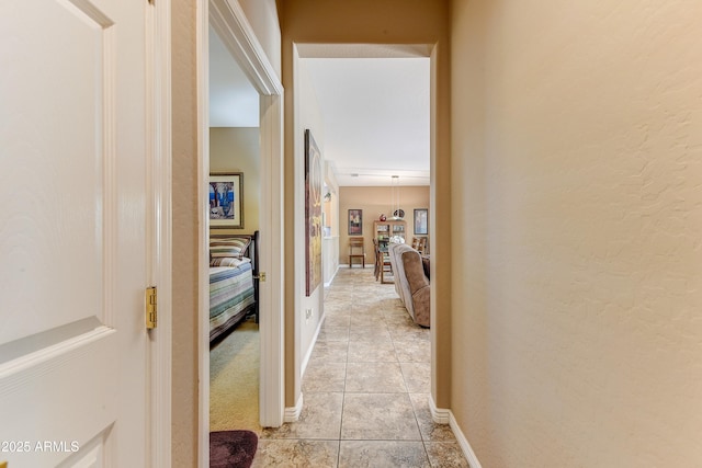 16857 W Villagio Dr, Surprise, AZ 85387 - hall featuring light tile patterned floors, baseboards, and a textured wall