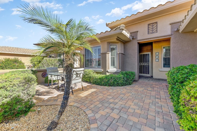 16857 W Villagio Dr, Surprise, AZ 85387 - doorway to property featuring a patio area, stucco siding, and outdoor dining space