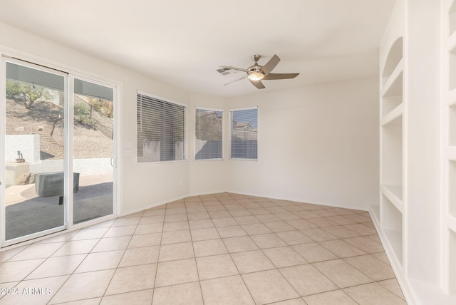 tiled empty room featuring ceiling fan