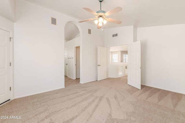 unfurnished bedroom featuring light carpet, ceiling fan, and high vaulted ceiling