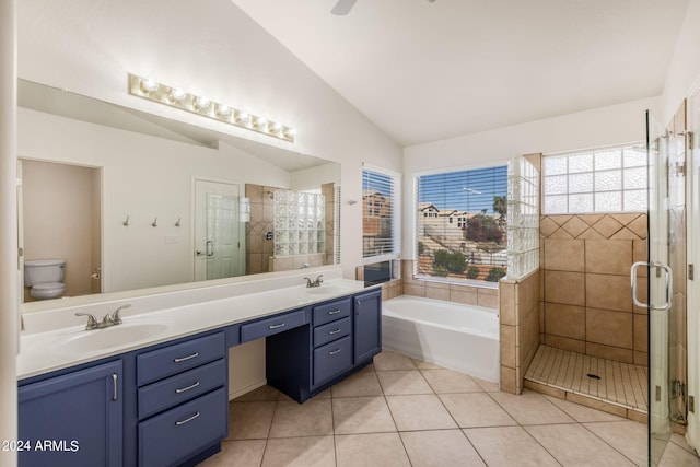 full bathroom featuring shower with separate bathtub, vaulted ceiling, tile patterned floors, vanity, and toilet