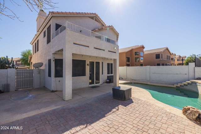 back of house with a fenced in pool and a patio