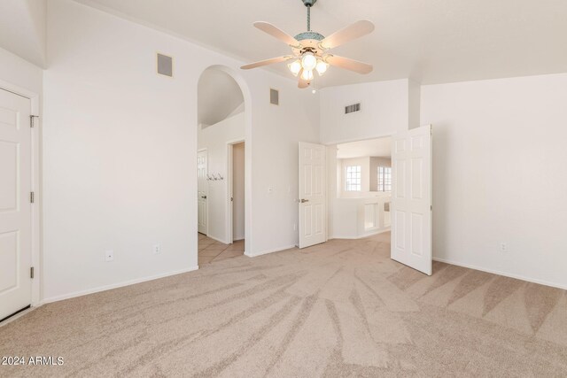 unfurnished bedroom with ceiling fan, light colored carpet, and high vaulted ceiling