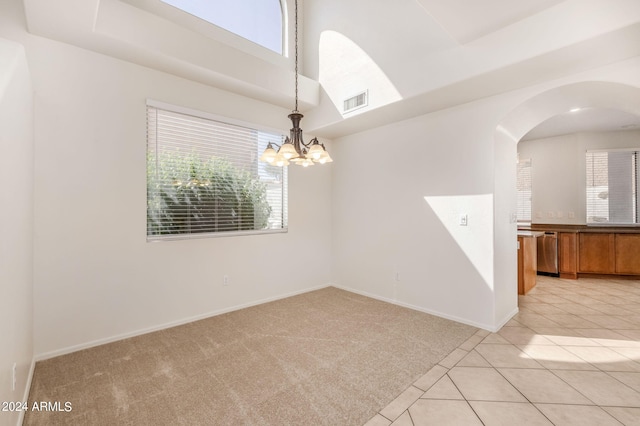 unfurnished room with light carpet and an inviting chandelier