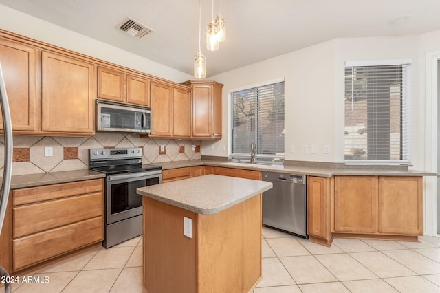 kitchen featuring appliances with stainless steel finishes, hanging light fixtures, tasteful backsplash, light tile patterned floors, and a center island