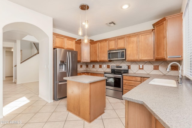 kitchen with light stone counters, sink, a kitchen island, backsplash, and appliances with stainless steel finishes