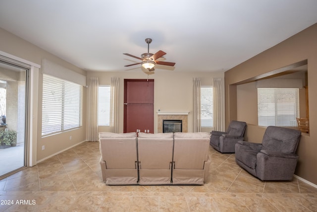 living room with ceiling fan and a tiled fireplace