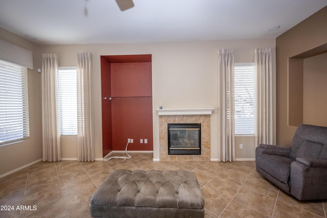 living room with ceiling fan, light tile patterned floors, and a tile fireplace