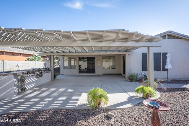 rear view of house featuring a pergola, a patio area, and exterior kitchen