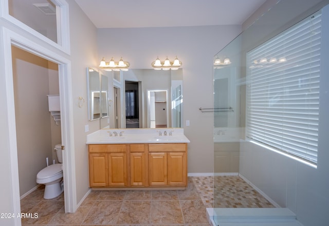 bathroom featuring tile patterned flooring, vanity, toilet, and walk in shower