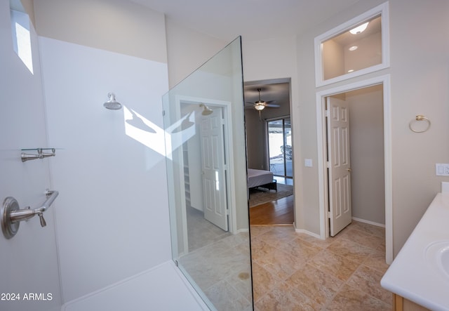 bathroom featuring ceiling fan, walk in shower, and vanity