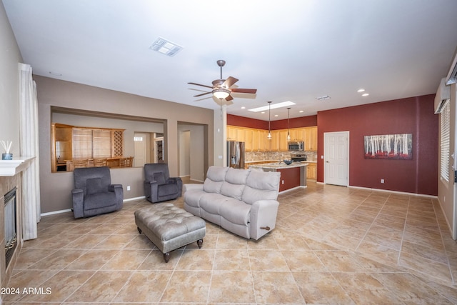 tiled living room featuring a tile fireplace and ceiling fan