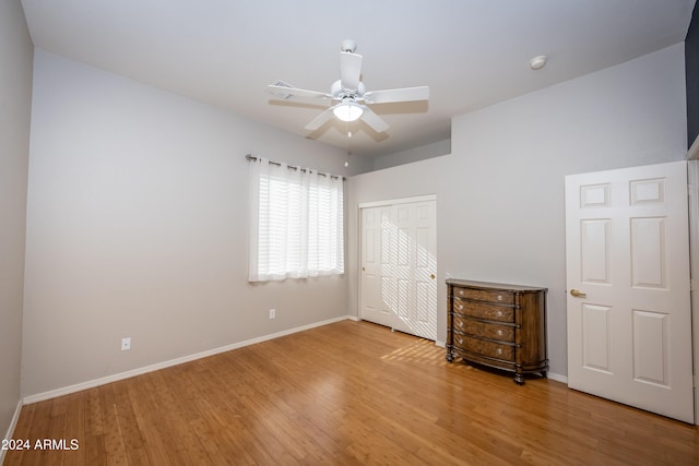 unfurnished bedroom with wood-type flooring, a closet, and ceiling fan