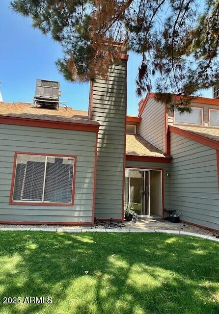 14002 N 49th Ave Unit 1021, Glendale, AZ 85306 - rear view of house with a chimney, a yard, and roof with shingles