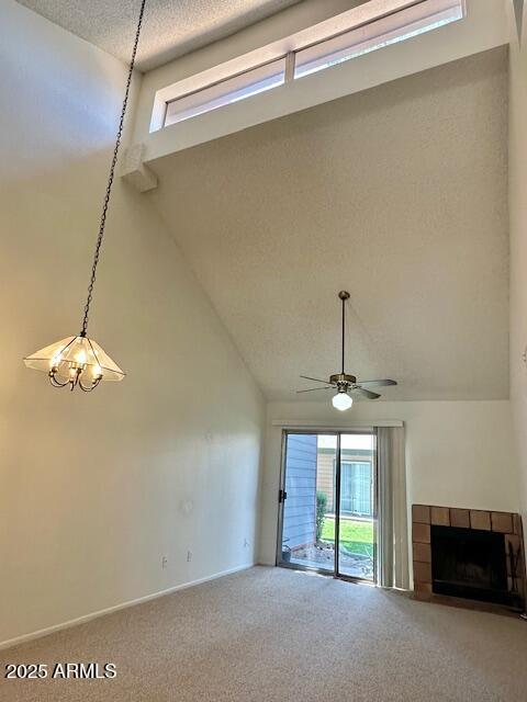 14002 N 49th Ave Unit 1021, Glendale, AZ 85306 - unfurnished living room with carpet, a ceiling fan, a fireplace, high vaulted ceiling, and a textured ceiling