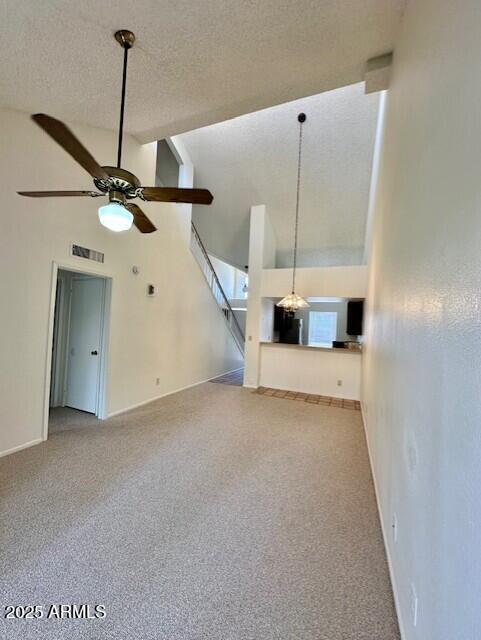 14002 N 49th Ave Unit 1021, Glendale, AZ 85306 - unfurnished living room with ceiling fan, high vaulted ceiling, carpet floors, and a textured ceiling