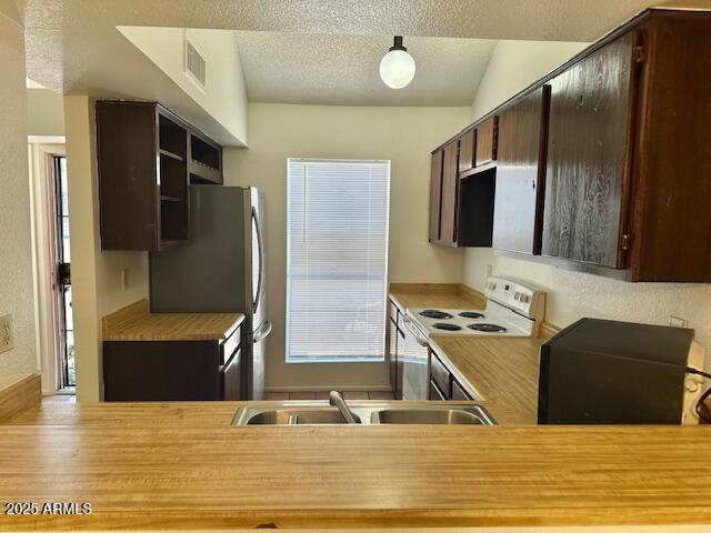 14002 N 49th Ave Unit 1021, Glendale, AZ 85306 - kitchen with white range with electric cooktop, dark brown cabinets, a textured ceiling, light countertops, and open shelves