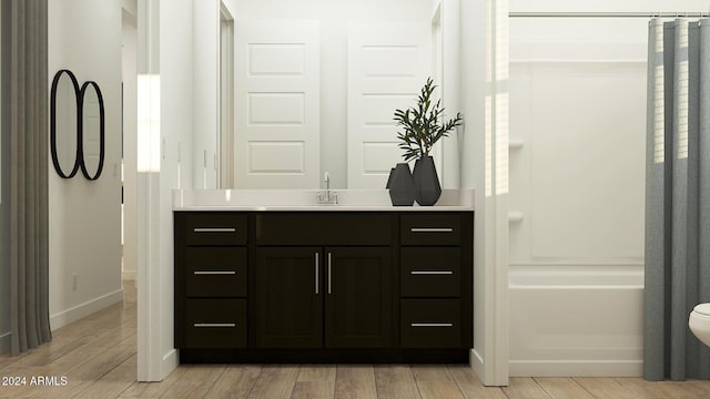 bathroom with hardwood / wood-style flooring, vanity, and toilet