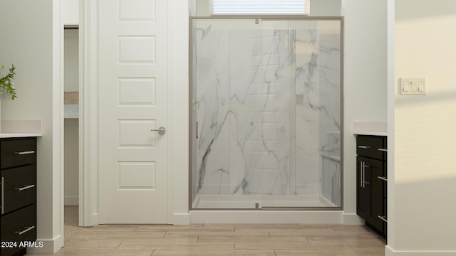 bathroom featuring hardwood / wood-style floors, vanity, and walk in shower