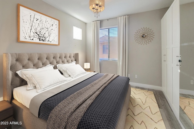 bedroom featuring a chandelier and light hardwood / wood-style floors