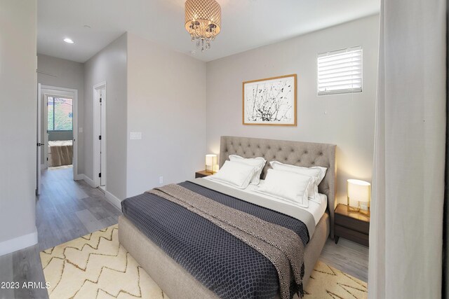 bedroom with an inviting chandelier and wood-type flooring