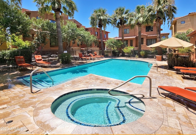 view of swimming pool featuring a hot tub and a patio