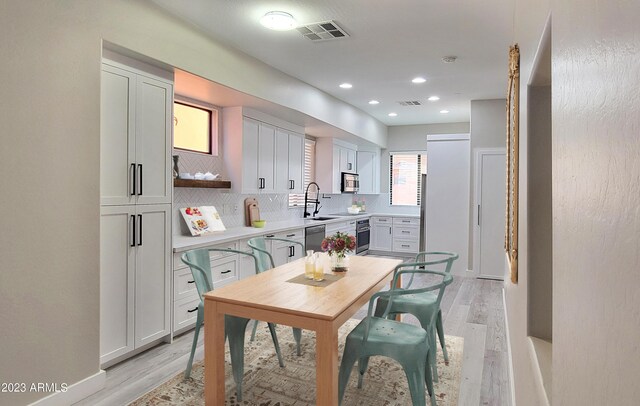 dining space featuring sink and light wood-type flooring