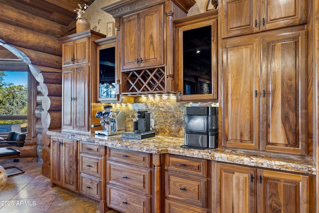 kitchen featuring lofted ceiling, backsplash, and light stone countertops