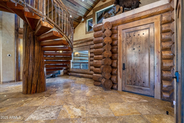 foyer featuring rustic walls, high vaulted ceiling, and wood ceiling