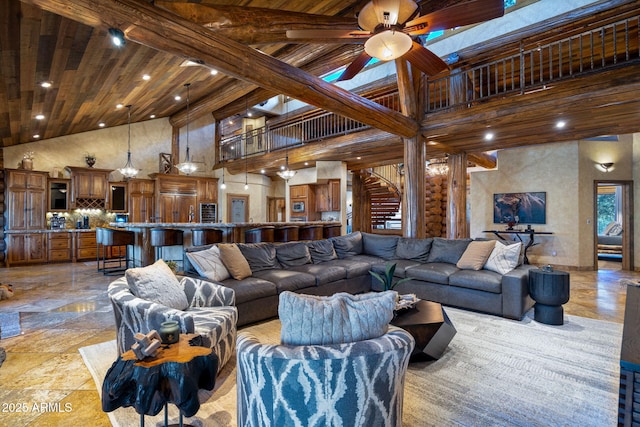 living room featuring a high ceiling, wooden ceiling, and ceiling fan