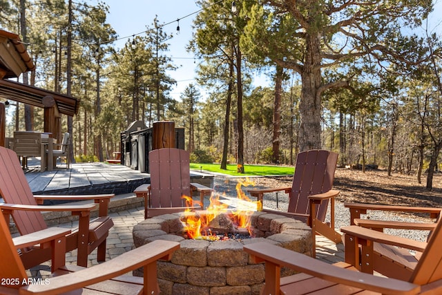 wooden deck with an outdoor fire pit and a patio area