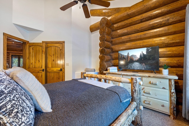 bedroom featuring ceiling fan, a towering ceiling, log walls, and carpet flooring